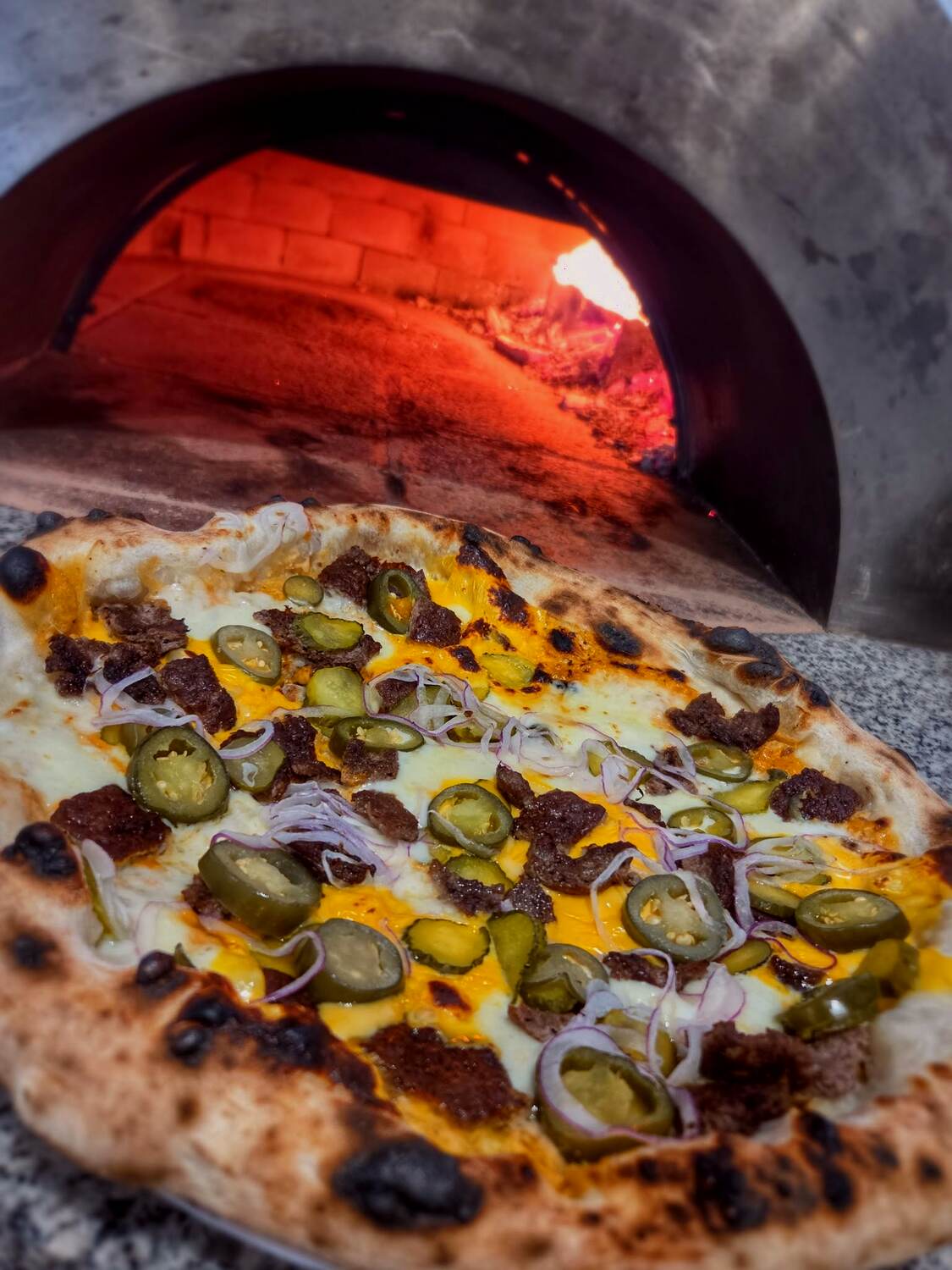 La Smashera pizza a kemence szája előtt, jalapenóval és csemegeuborkával