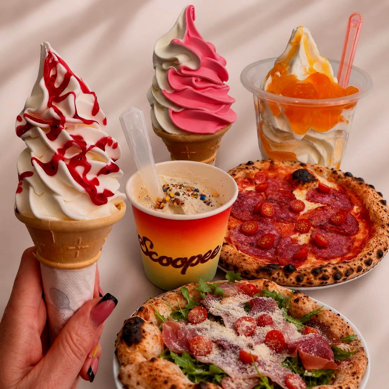 Csavart fagyik tölcsérben és pohárban, mellettük egész pizzák