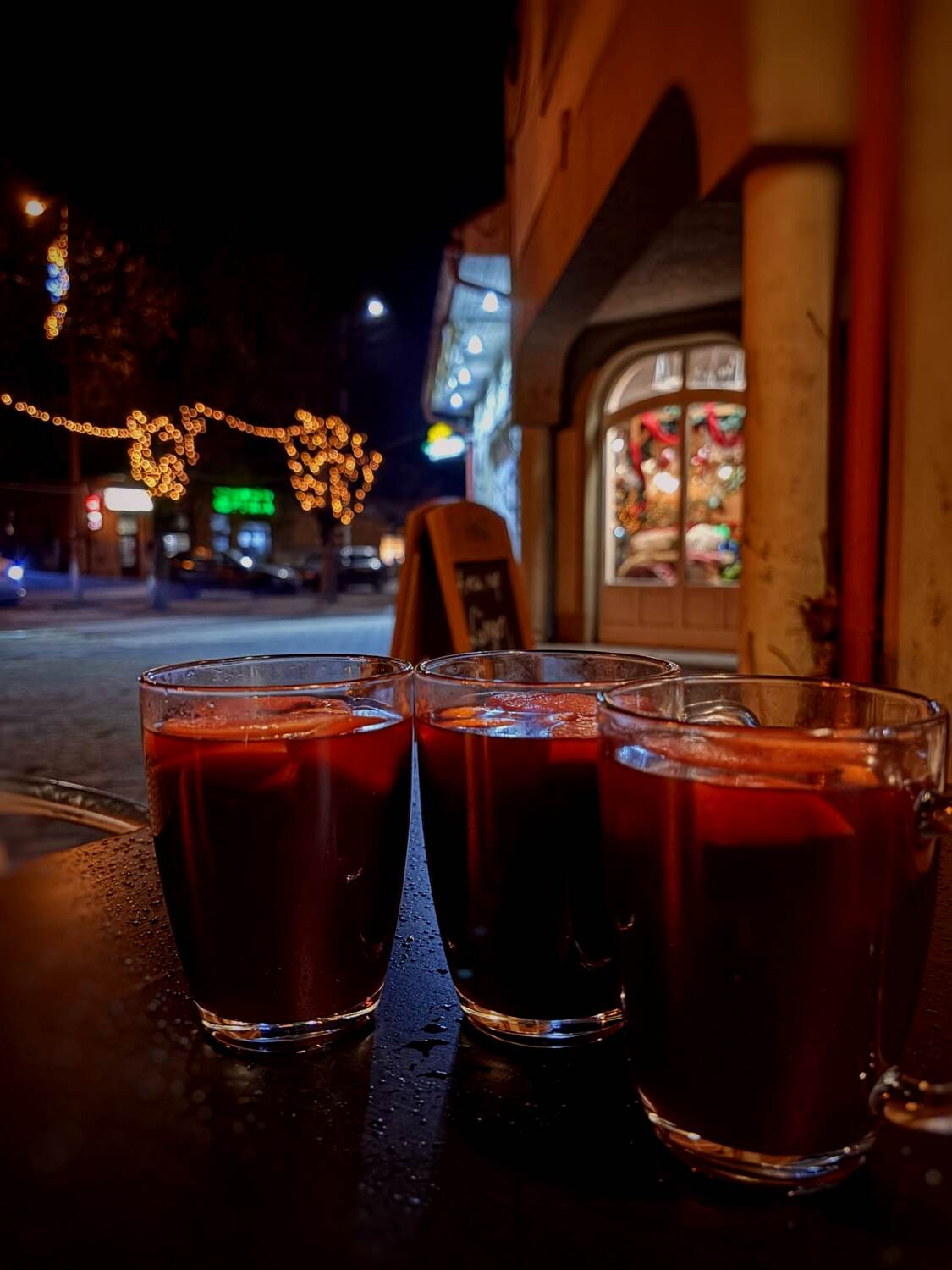 Forralt boros poharak az esti utcán, adventi fényekkel